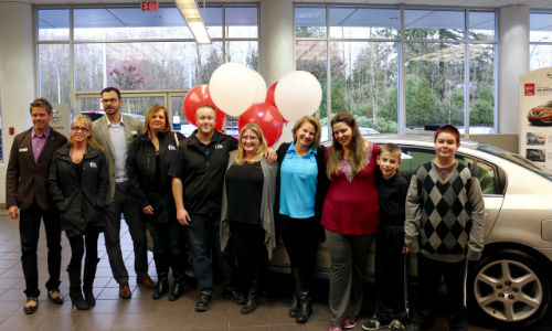 Noelani Dreger, her sons Gaberial and William, and some of the team from Fix Auto Abbotsford who helped get Dreger into a refurbished Nissan Altima in time for the holidays.