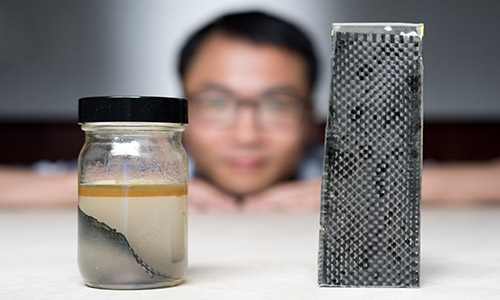 A research team at Georgia Tech has developed a new way of recycling carbon. Pictured above, one of the men involved in the project Kai Yu shows off the team's method - immersing carbon fibre composites in alcohol.