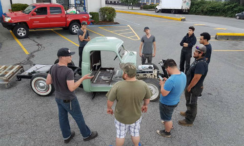 CUT Program participants and volunteers discuss a current build, a '47 Chevy pickup. The program, which provides at-risk youth with practical experience, needs a new space in which to continue its work.