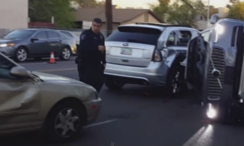 The scene of a recent accident in Arizona involving an Uber self-driving vehicle (right). According to one eyewitness, who thought the Uber had a human driver, 'It was the (Uber) driver's fault for trying to beat the light and hitting the gas so hard.'