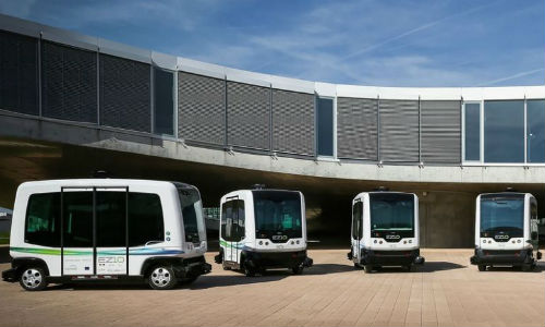 Small autonomous buses in use at an office park in California. Cities may one day supplement their own transit networks with similar fleets or even ordinary autonomous cars.