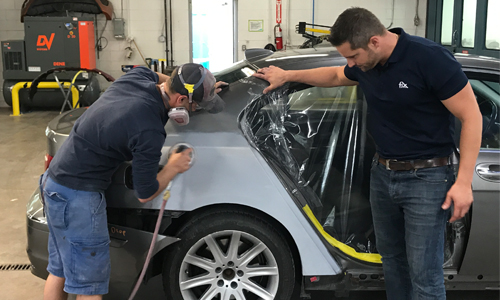 Johnny D'Ambrosio, co-owner of Fix Auto St. Catharines, working with a young technician. The shop has fostered a culture that encourages young people to stay and advance.