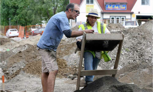 Shop owner Nick Papadatos inspects possible artifacts with Shelley Birch, a Caldwell First Nation archeology monitor, during a dig next to his shop in Windsor, Ontario.