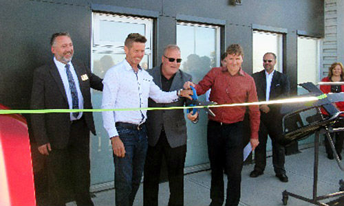 Dave Miller and Mike Davis cutting the ribbon at the official grand opening of Fix Auto Airdrie. Davis and Miller are also co-owners of facilities in Calgary and Lethbridge.